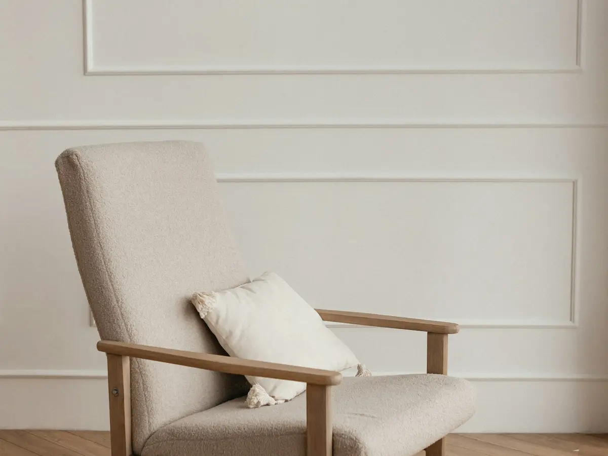 A light armchair with a cushion beside a panelled wall in the office
